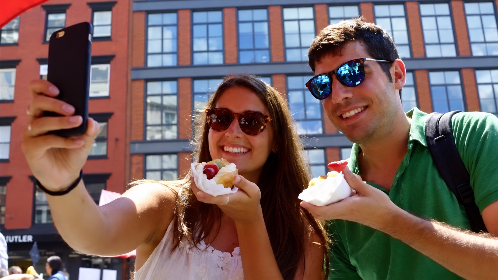 Two people taking a selfie with hot dogs.