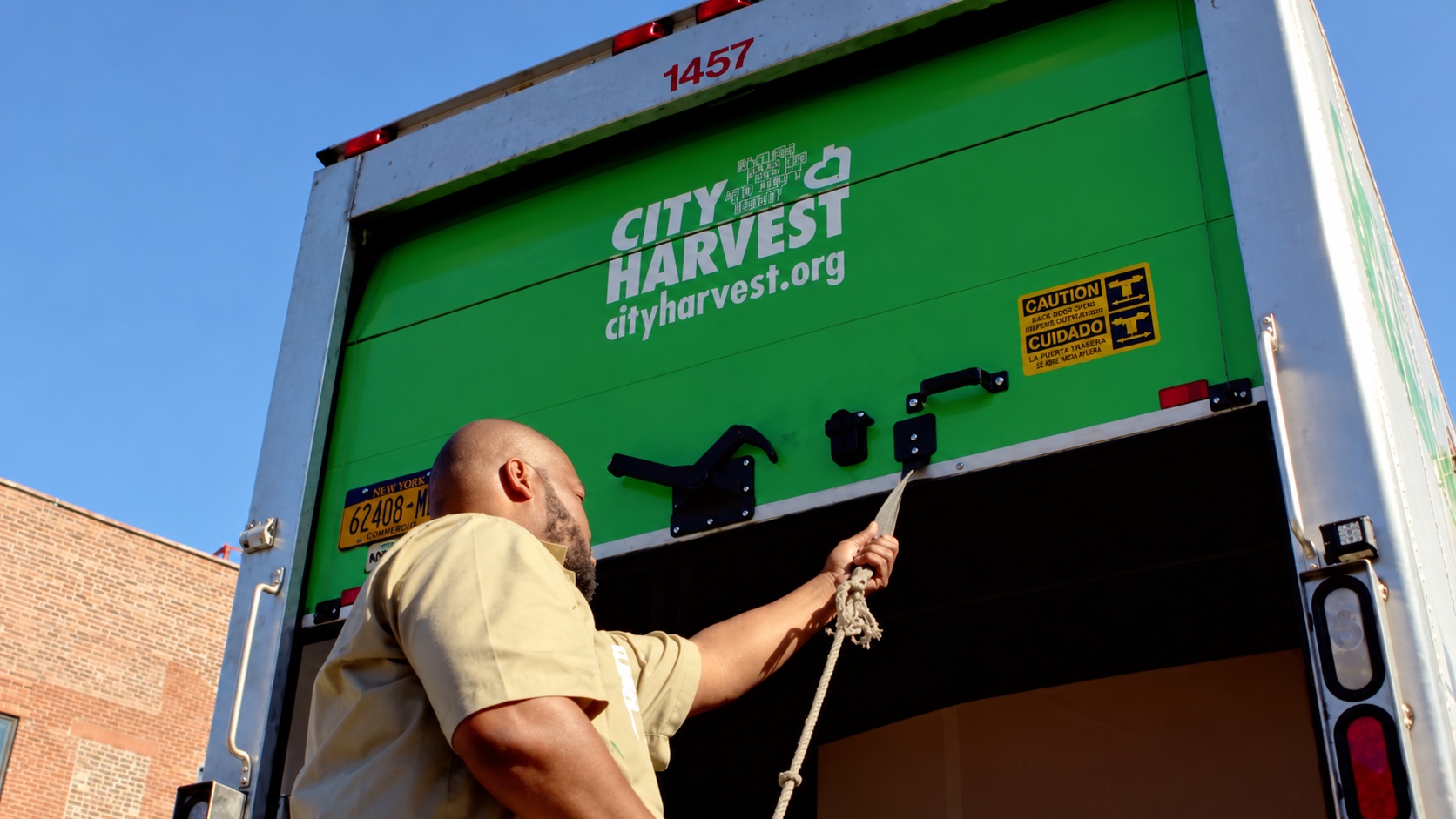 A man loading a City Harvest truck.