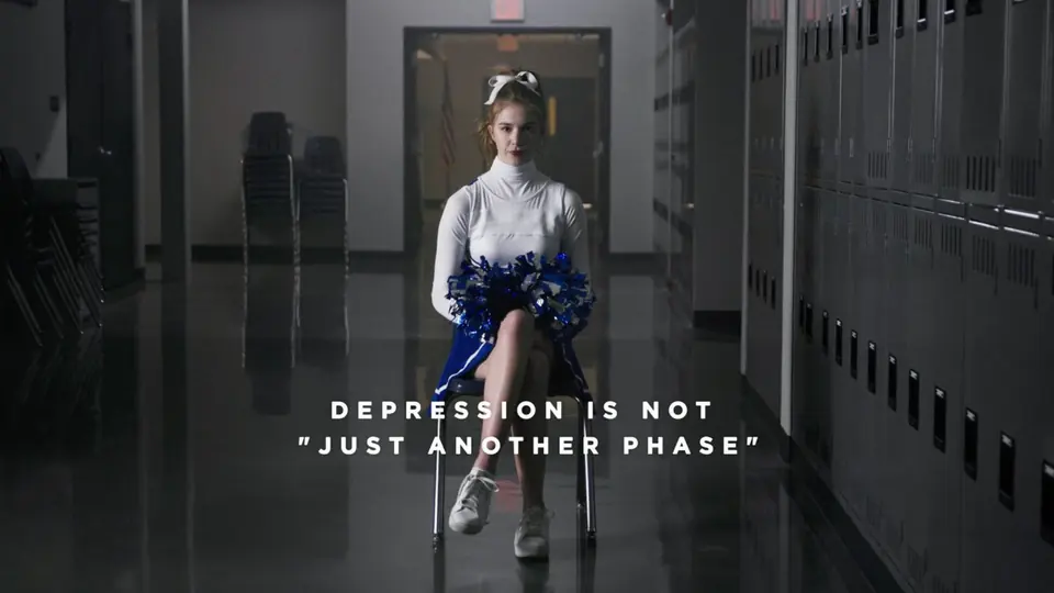 A cheerleader sitting in the same hallway.