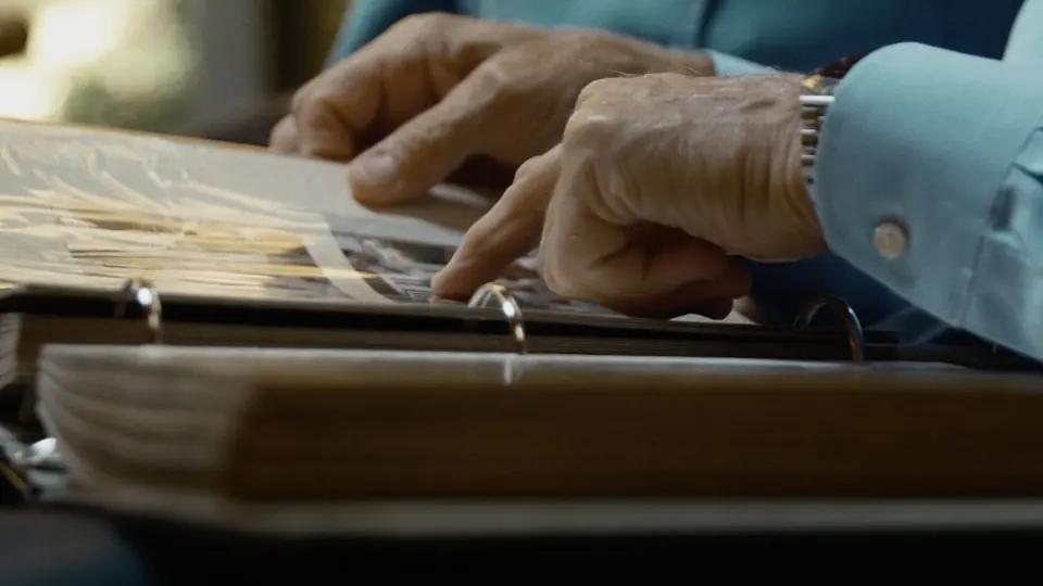 A close-up of hands turning the pages of an album.