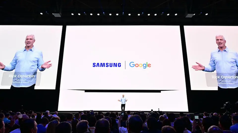 A presenter on stage in front of a Samsung and Google slide.