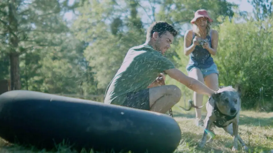 A couple with a dog and a river tube.