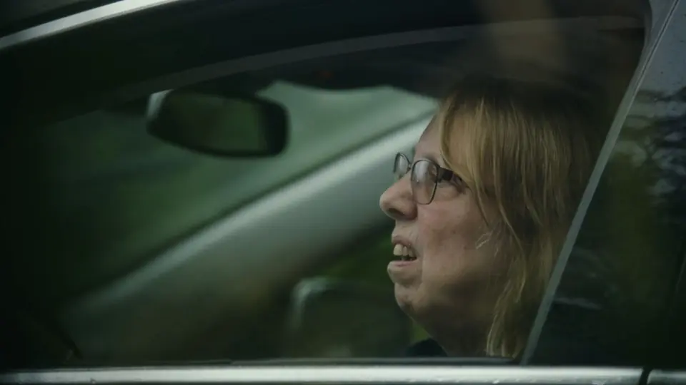 A woman reacting in her car.